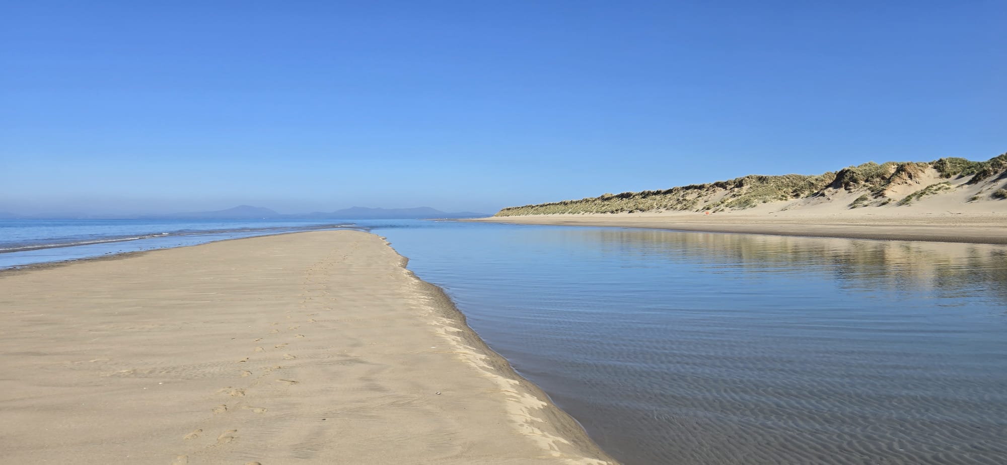 Tidal channel running out to the dunes and mountains
