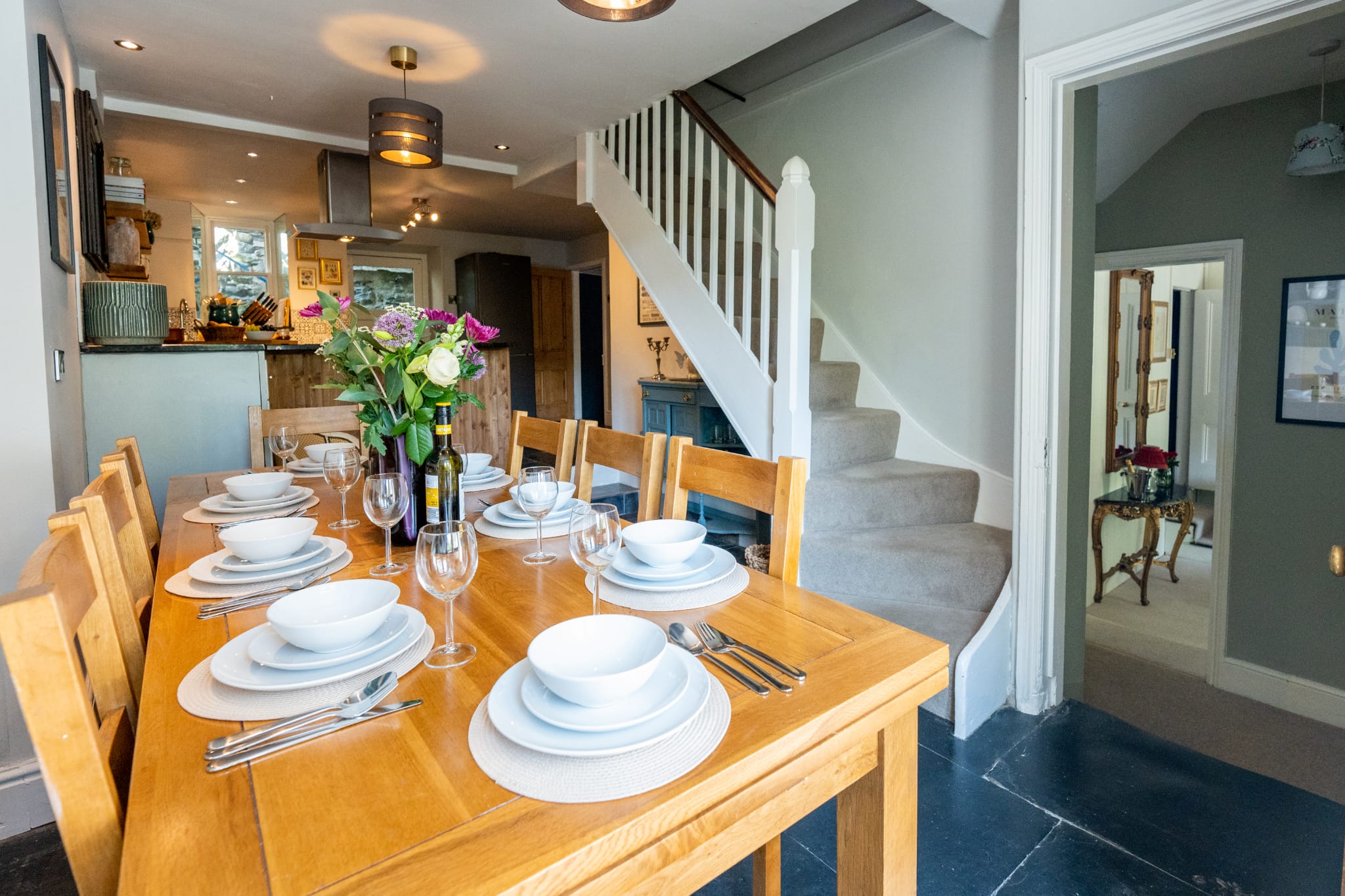 The dining table set for ten beside the staircase
