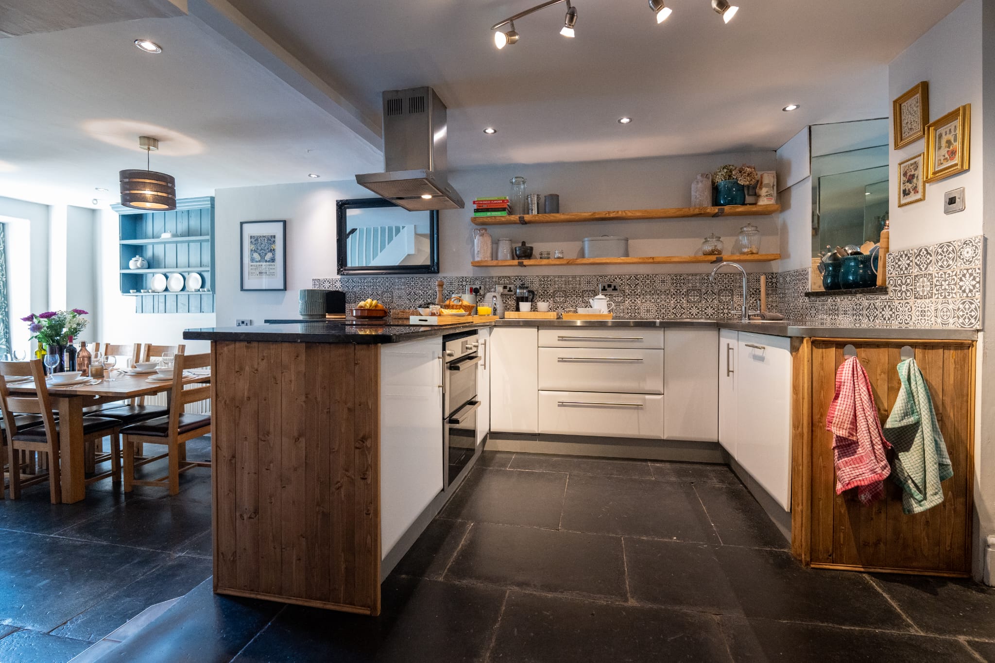 The open-plan kitchen with island, range and patterned splashback