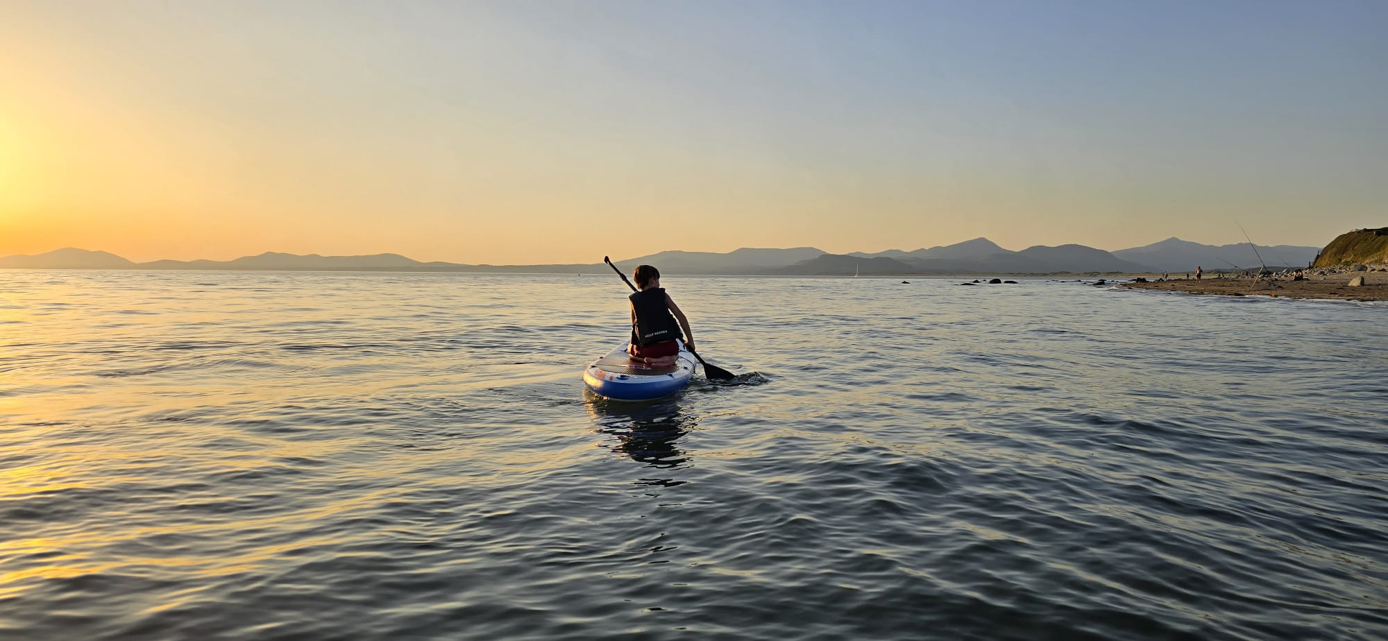 Paddleboarding at sunset on Cardigan Bay